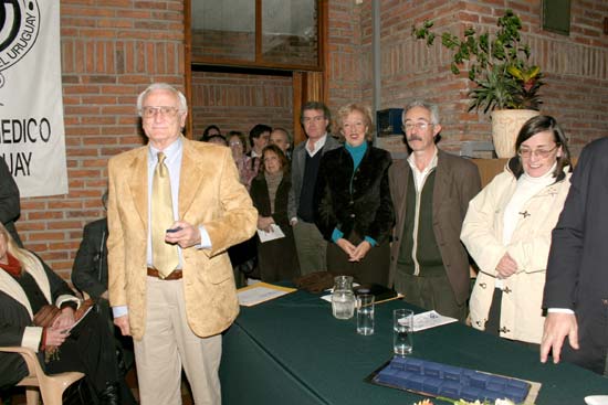 Dr. Nelson Albertoni Tonna (de Salto) recibe su Distinción Sindical. Detrás lo observan: Dres. Enrique Soto Durán, Ministra de Salud Pública Dra. María Julia Muñoz, Decano de la Facultad de Medicina de UDELAR, Dr. Felipe Schelotto y Dra. Alicia Ceres, Secretaria del Comité Ejecutivo del SMU.